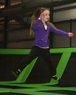Girl Jumping on Trampoline at Indoor Park